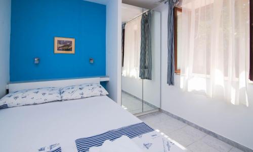 Bett in einem Zimmer mit blauer Wand in der Unterkunft Villa Glencoe -suite 3 in Mali Lošinj