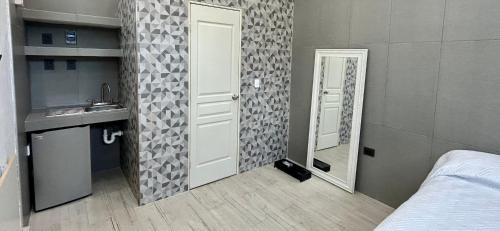 a bathroom with a door and a sink and a mirror at Rose 5 in Cancún