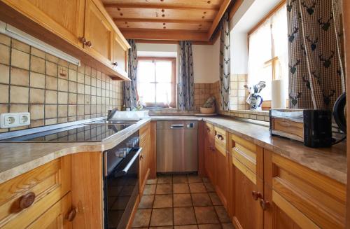 a kitchen with wooden cabinets and a sink and a window at FIVE SEASONS - Hideaway Saalbach in Saalbach-Hinterglemm