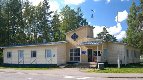 ヨエンスーにあるPartiotalon retkeilymaja - Scouts Hostelの通り沿いにある小さな黄色と白の建物