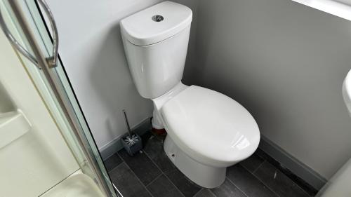 a white toilet in a bathroom with a shower at Homestay in Walsall in Walsall
