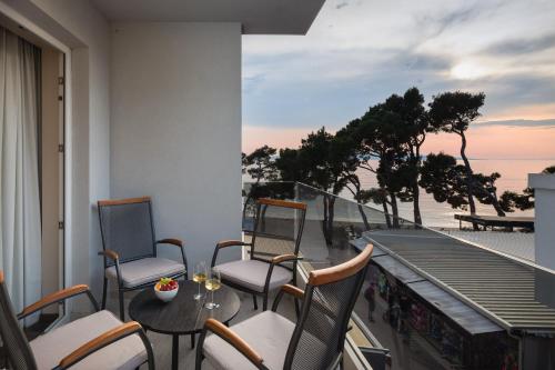 a balcony with chairs and a table with a view of the ocean at Hotel Central Beach 9 in Makarska