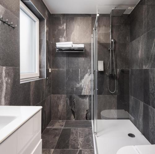 a bathroom with a shower and a sink at Hotel Central Beach 9 in Makarska