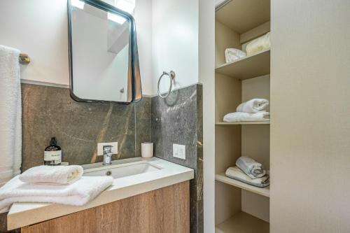 a bathroom with a sink and a mirror and towels at Casa de Armonia in Tamarindo