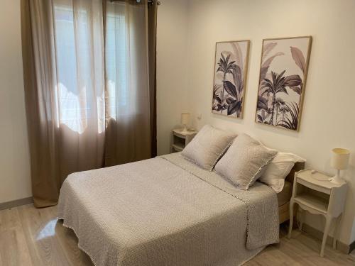 une chambre avec un lit et deux tableaux au mur dans l'établissement Résidence Soleado Maison jumelée à 800m du centre ville de Bédoin, à Bédoin