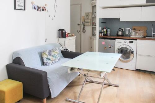 a living room with a couch and a table at A cosy little nest in the 5th arrondissement in Paris