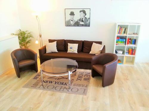 - un salon avec un canapé brun et 2 chaises dans l'établissement Ferienwohnung Anna, à Winterberg