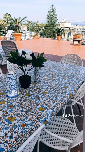 a table with a blue and white table cloth with a plant on it at La Terrazza Quisisana Sorrento Coast in Castellammare di Stabia