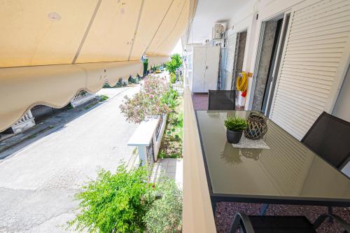 a balcony with a table and benches on a building at Viny Apartment in Paralia Dionysiou