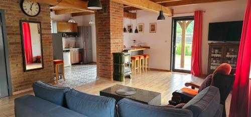 a living room with blue couches and a brick wall at Domek Przy Rzece in Kazimierz Dolny