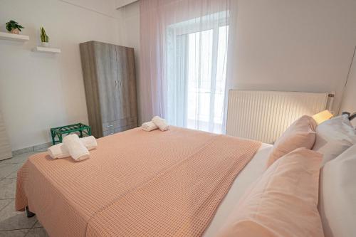a bedroom with a bed with two towels on it at Viny Apartment in Paralia Dionysiou