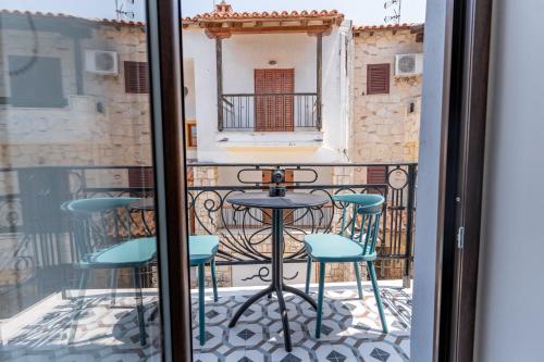a balcony with a table and chairs on a balcony at IKIA KATSANI in Afitos