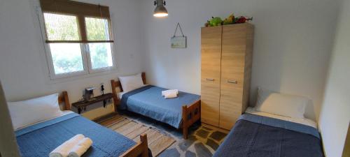 a small room with two beds and a cabinet at Aiolos in Kalamaki Messinia
