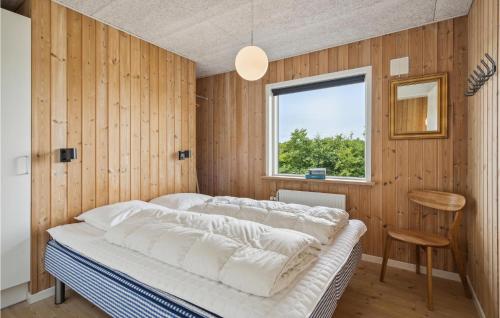 StavningにあるCozy Home In Skjern With Wifiの窓のある木製の壁のドミトリールームのベッド1台分です。