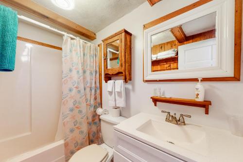 Un baño con lavabo, inodoro y espejo. en The House on Hobson Lane, en Wells