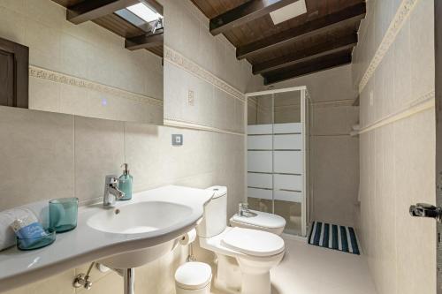 a bathroom with a white sink and a toilet at Casa Los Pinos in Mogán