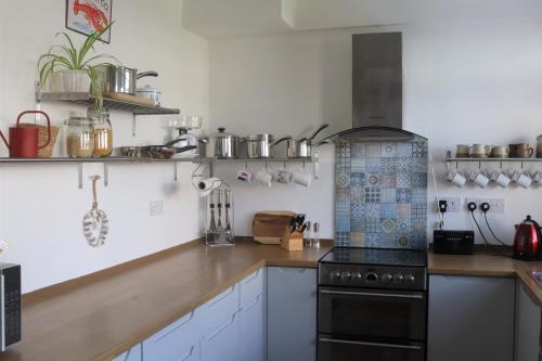 a kitchen with white cabinets and a stove top oven at Sealladh Na Mara, Pittenweem in Pittenweem