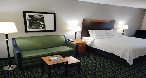 a hotel room with a bed and a green couch at Best Western Louisville South - Shepherdsville in Shepherdsville