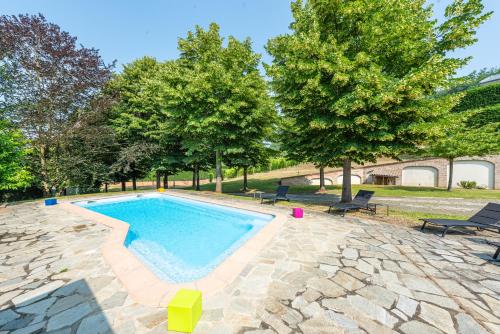 - une piscine entourée de chaises et d'arbres dans une cour dans l'établissement Villa Cornelia , entire Villa with private pool, à Corneliano d'Alba