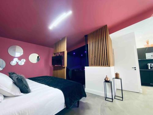 - une chambre avec un grand lit aux murs roses dans l'établissement La Litchi Le 50 Suites and Spa centre ville, à Bordeaux