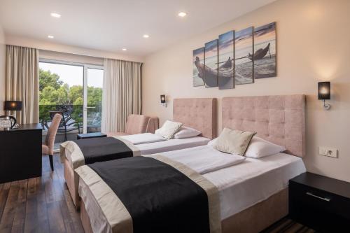 a hotel room with two beds and a balcony at Hotel Central Beach 9 in Makarska