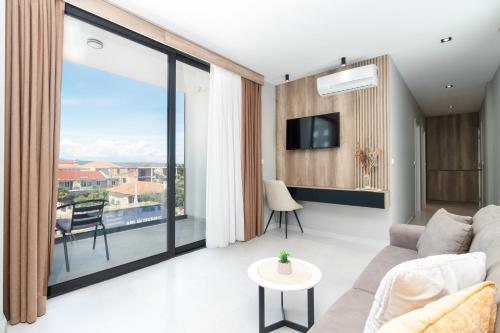 een woonkamer met een bank en een groot raam bij Trio Resort in Ulcinj