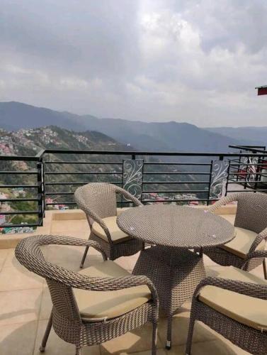a patio with tables and chairs on a balcony at Superb Luxury Three Bed Apartment in Shimla