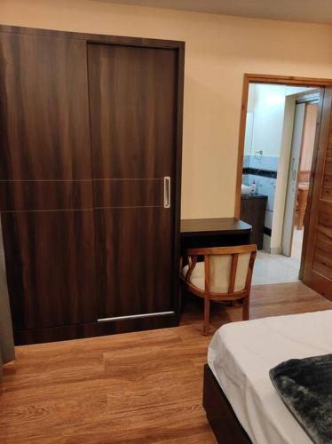 a bedroom with a large wooden door and a desk at Superb Luxury Three Bed Apartment in Shimla