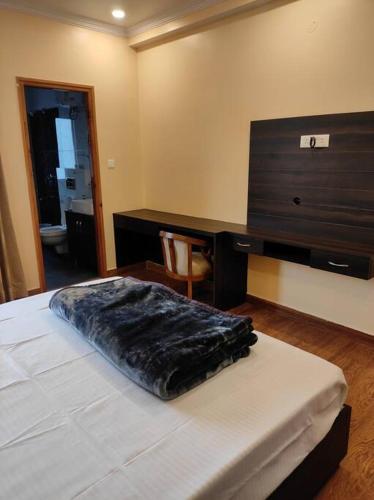 a bedroom with a bed with a dresser and a desk at Superb Luxury Three Bed Apartment in Shimla