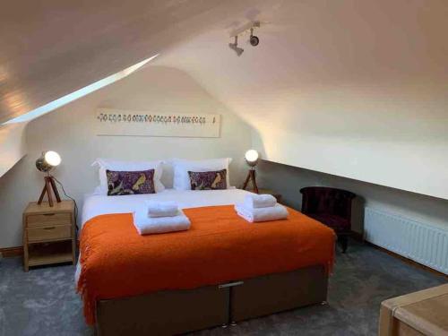 a bedroom with a large bed with orange sheets at Wyresdale 7 Limethwaite in Windermere