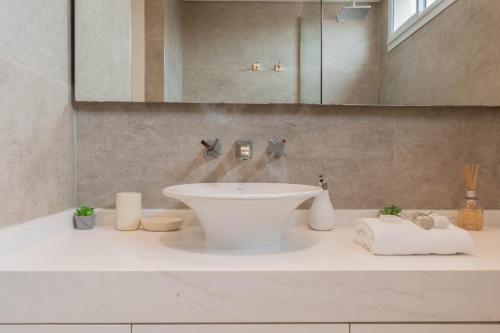 y baño con lavabo blanco y espejo. en Las Heras 2700 - Luxury 3 Bd Palermo Chico en Buenos Aires