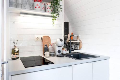 a kitchen with white cabinets and a sink at Igluhut on the South Coast of Lohusalu 200m from the Sea! in Lohusalu