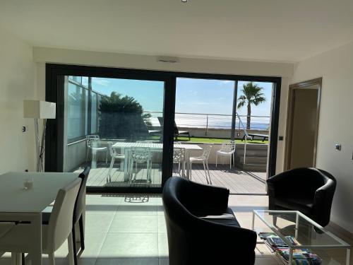 un salon avec une table et des chaises sur un balcon dans l'établissement Appartement moderne face à la mer, à Sanary-sur-Mer