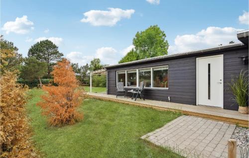 a black house with a picnic table in a yard at 5 Bedroom Nice Home In Asperup in Asperup
