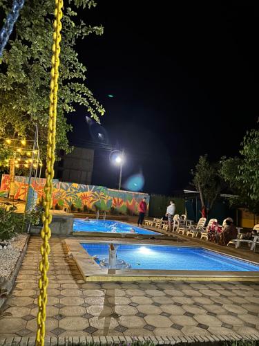 a swimming pool at night with people sitting around it at Гостевой дом Асель in Cholpon-Ata
