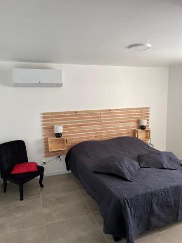 une chambre avec un grand lit et une chaise dans l'établissement Les Flo location, à Aigues-Mortes