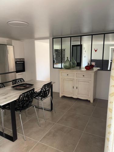 une cuisine avec une table et des chaises dans une pièce dans l'établissement Les Flo location, à Aigues-Mortes