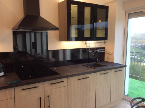 a kitchen with a sink and a stove at Le PANORAMA Maison Blanche in Tulle