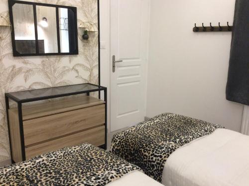 a room with a bed and a mirror and a dresser at Le PANORAMA Maison Blanche in Tulle