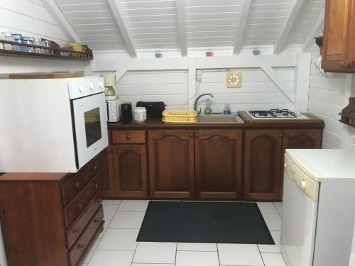 a small kitchen with wooden cabinets and a sink at Tite halte in Saint-Claude