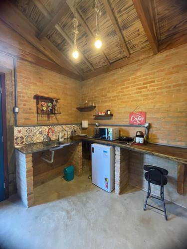 eine Küche mit einer Theke und einem Kühlschrank im Zimmer in der Unterkunft CAFOFO DA GIO in Conceição da Ibitipoca