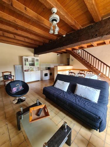 un salon avec un canapé bleu et une table dans l'établissement Chez Lili Maison de campagne gîte familial, à Saint-Mesmin