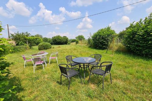 a group of tables and chairs in a field at Chez Lili Maison de campagne gîte familial in Saint-Mesmin