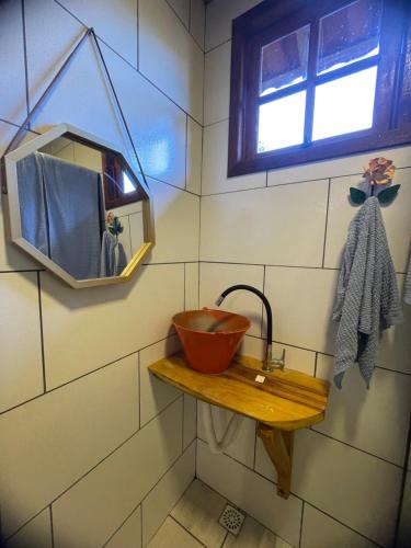 ein Badezimmer mit einem hölzernen Waschbecken und einem Spiegel in der Unterkunft CAFOFO DA GIO in Conceição da Ibitipoca