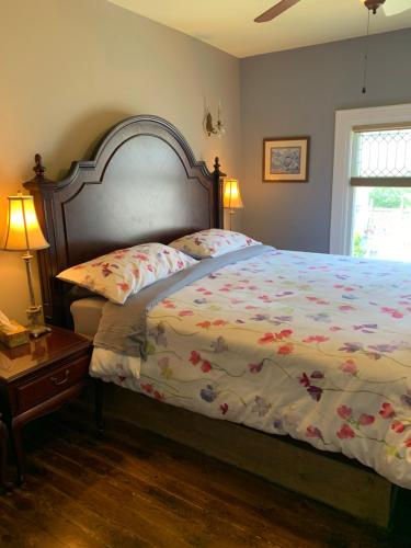 a bedroom with a bed with a floral comforter at Green Oaks B&B in Niagara on the Lake