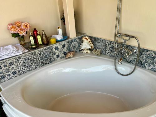 a bath tub with a shower in a bathroom at Holiday Oasis with private patio and Hammam-style bath in Chora-Pithagoreo, Samos Island in Chóra