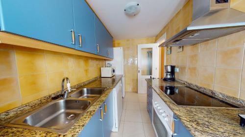 デニアにあるApartamento Sergi by Family Homesのキッチン(ステンレス製のシンク、青いキャビネット付)