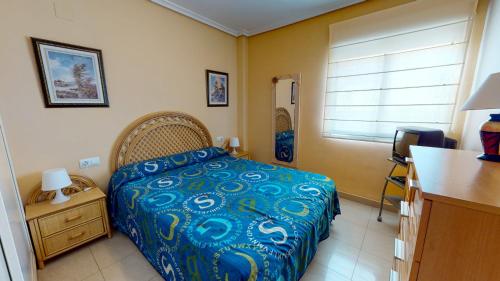 デニアにあるApartamento Sergi by Family Homesのベッドルーム1室(青い掛け布団付きのベッド1台付)