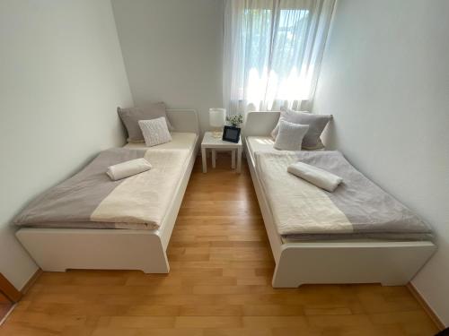 Duas camas num pequeno quarto com uma janela em GHR Apartment em Simbach am Inn