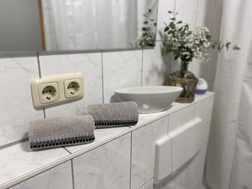 uma casa de banho branca com um lavatório e um espelho em GHR Apartment em Simbach am Inn
